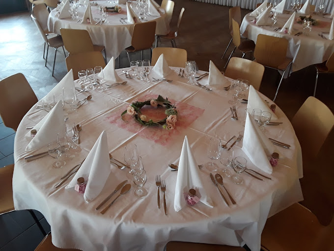 Table ronde dressée pour un repas de famille dans la petite salle du restaurant Maison de Ville à Vuippens