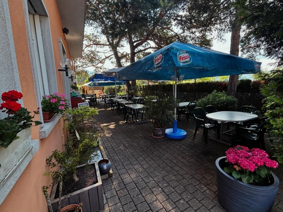 Terrasse du restaurant avec tables dressées à l’ombre des parasols